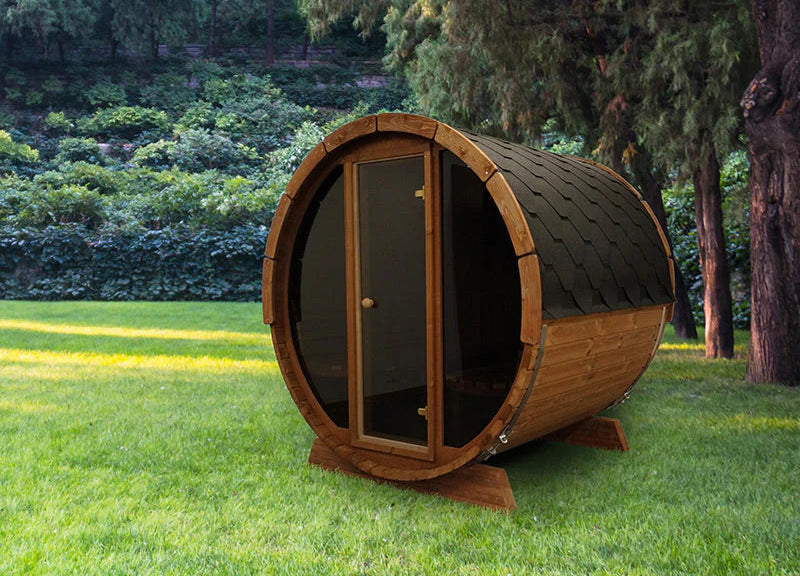Wooden barrel-shaped structure in a garden setting with trees in the background