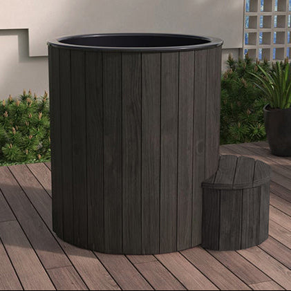 Dark wooden planter on a wooden deck with a garden background